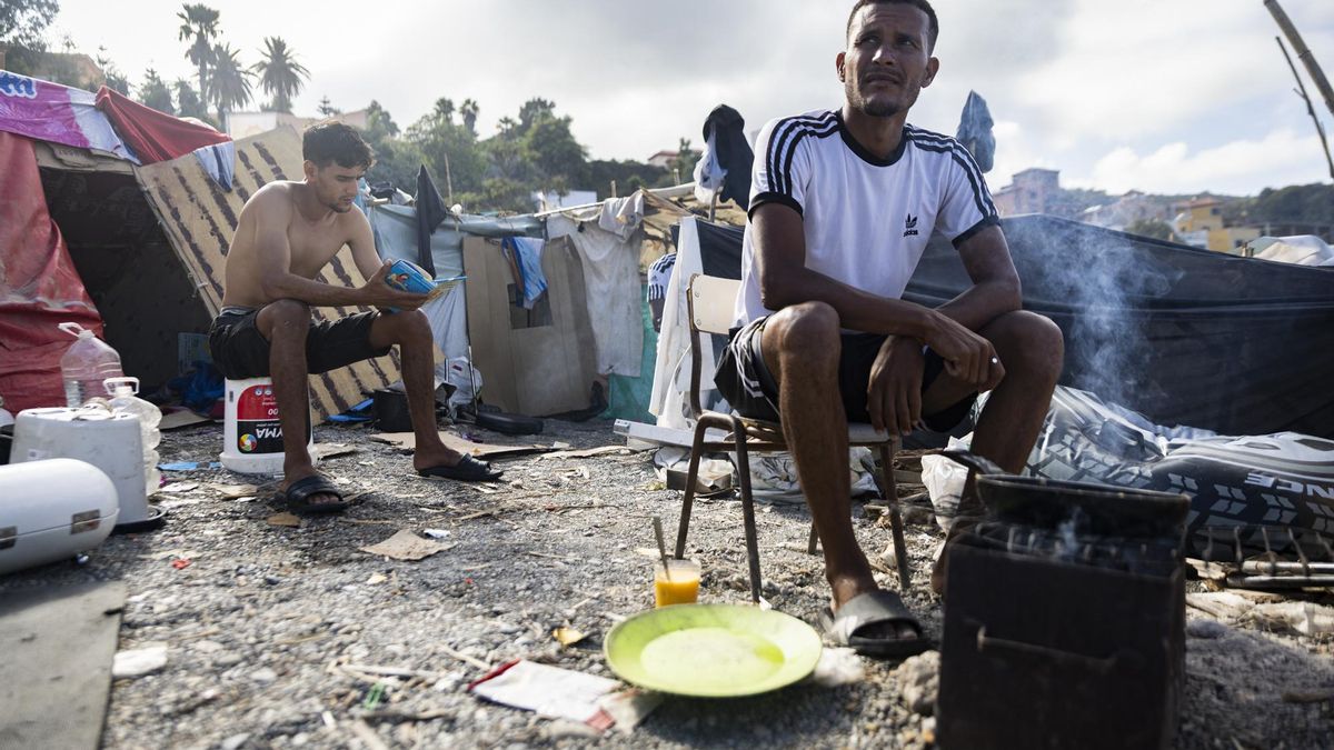 Varios de los jóvenes migrantes comiendo en el asentamiento en la playa de El Trampolín.