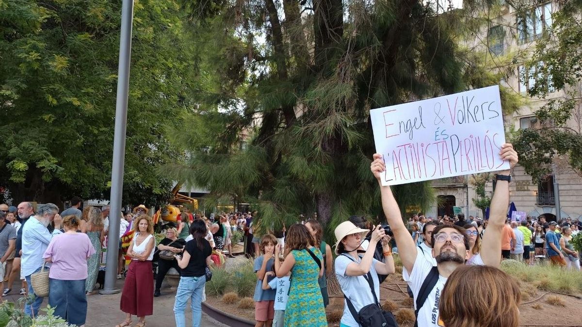 Un joven con una pancarta en la que describe una de las principales inmobiliarias de Europa como "el activista peligroso".