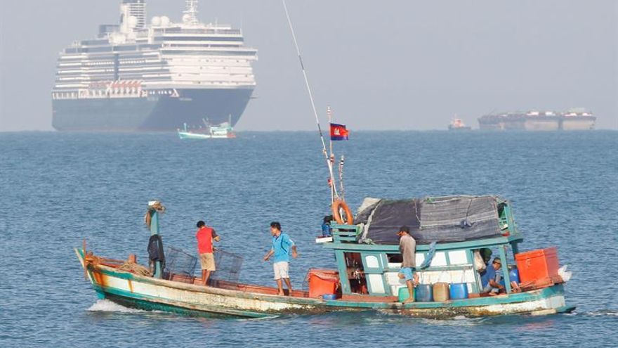 Un bote camboyano pasa por delante del crucero  MS Westerdam, el crucero de la naviera Holland America Line, fondeado delante de la costa de Sihanoukville. Con 2.000 personas a bordo, recibió el permiso de las autoridades camboyanas tras ser rechazado por cinco países ante el temor de que alguno de los pasajeros esté enfermo de Covid-19 por el nuevo coronavirus.