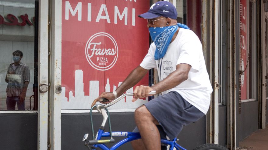 Un hombre maneja bicicleta cubriendo su rostro en el centro de Miami, Florida (EE.UU.), hoy 22 de julio de 2020. EFE/EPA/CRISTOBAL HERRERA-ULASHKEVICH