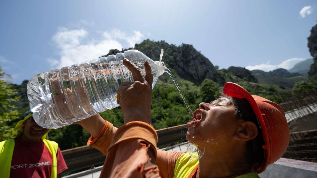 Un trabajador se refresca durante la ola de calor de julio de 2025.