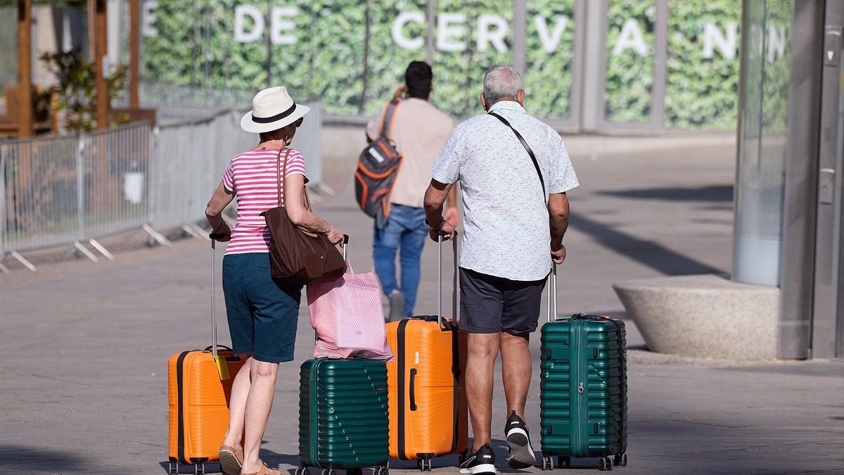 Una pareja de jubilados espera, con las maletas, en Madrid