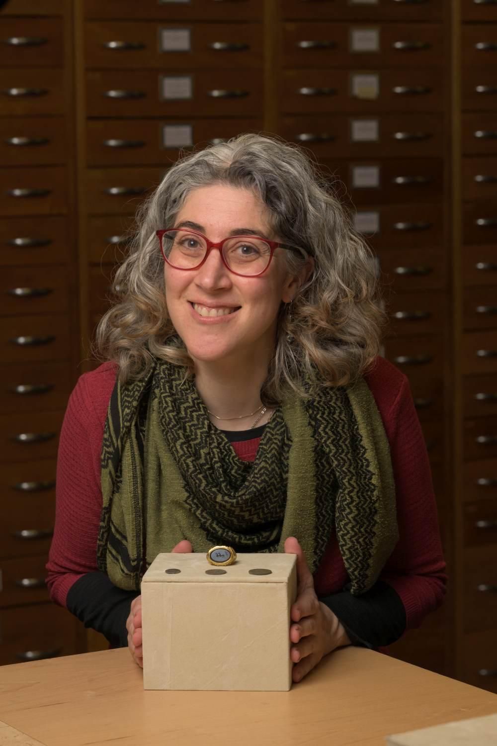 Amal Khreisheh, conservadora principal de South West Heritage Trust, con el anillo de Ilminster y monedas del tesoro.