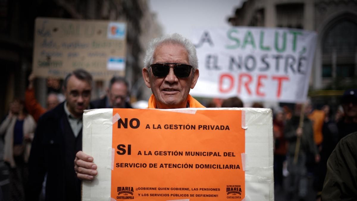 Un hombre sujeta un cartel de protesta durante una manifestación contra la privatización de la sanidad, a 7 de abril de 2024, en Barcelona, Catalunya (España)