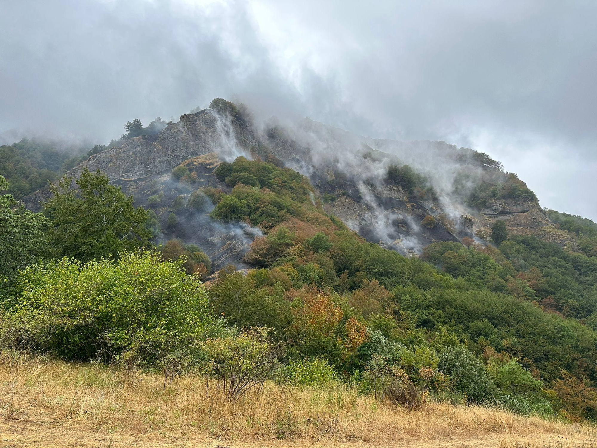 Humo sin llama aparente todavía en el incendio cerca de Caín, en Picos de Europa, a pesar de la lluvia.