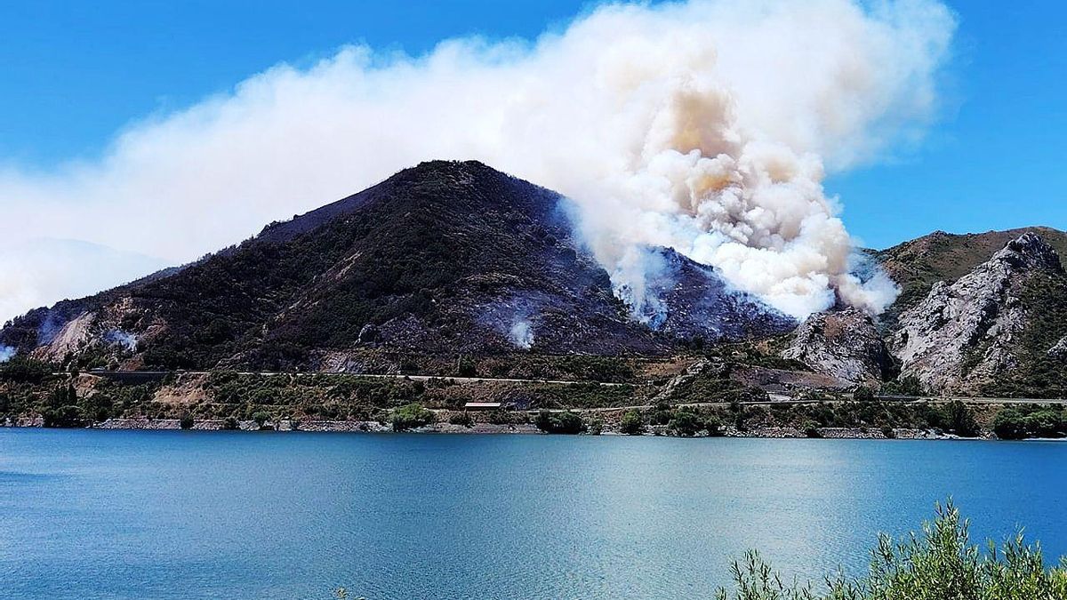 Un incendio forestal cerca de la Autopista AP-66 desde la otra orilla del pantano en la salida hacia Sena de Luna.