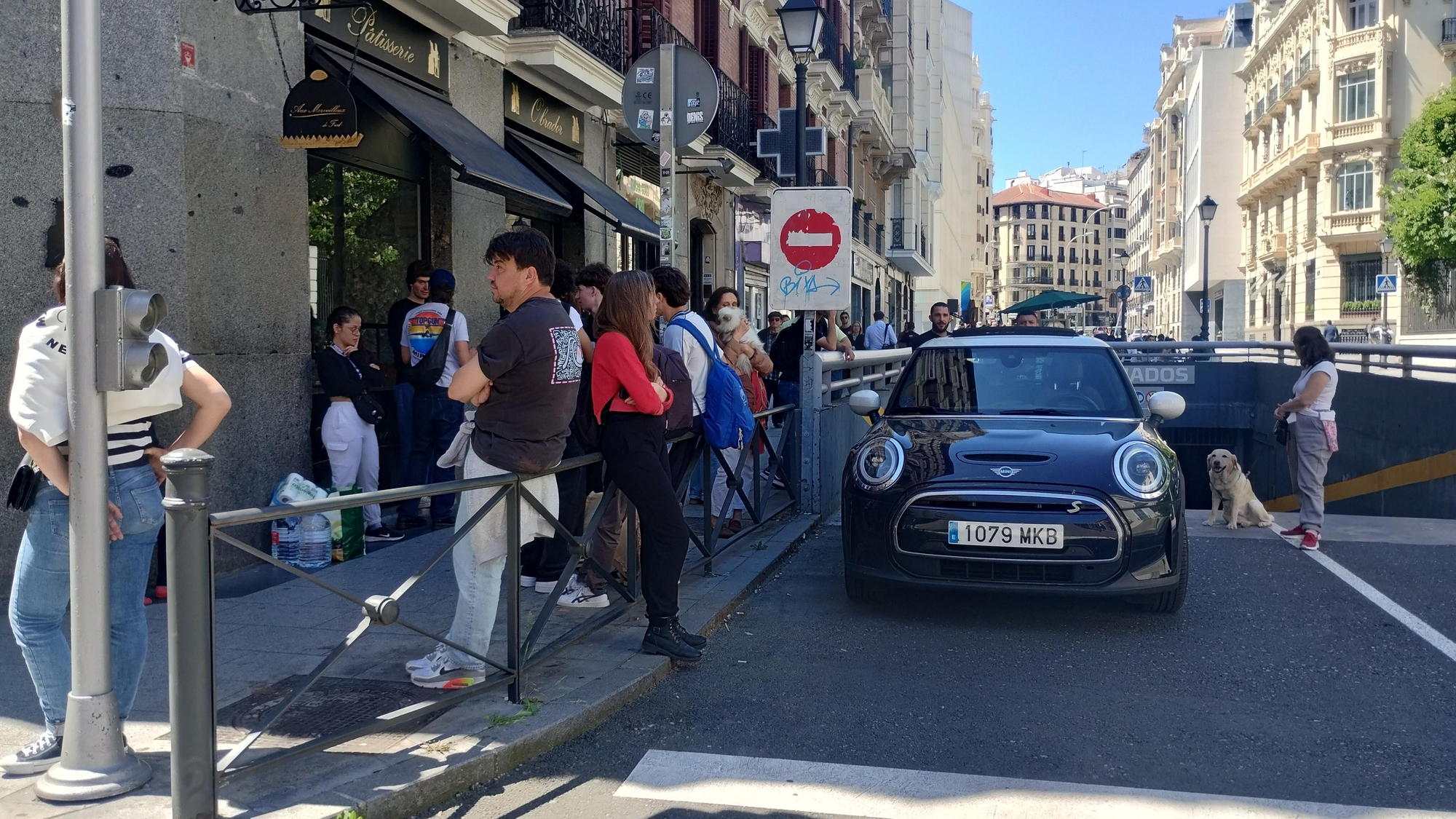 Varias personas escuchan la radio de un coche cerca del Mercado de Barceló