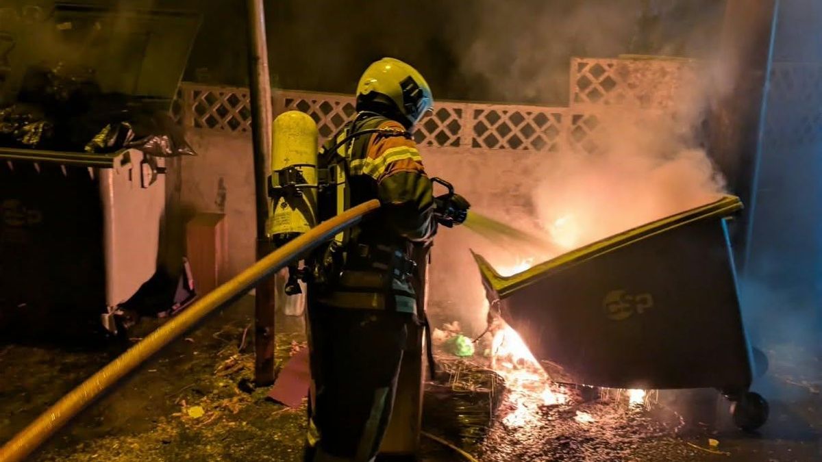 Un bombero apagando el incendio de un contenedor,  en el municipio de El Paso, en la madrugada de este  lunes.