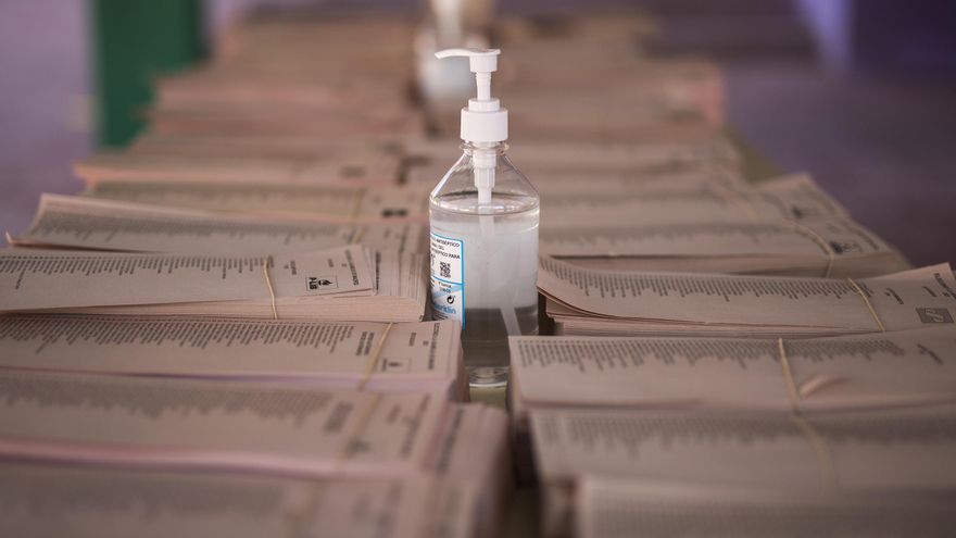 Gel hidroalcohólico con papeletas electorales en el Colegio Público Asturias en el distrito Puente de Vallecas, a 4 de mayo de 2021, en Madrid (España).
