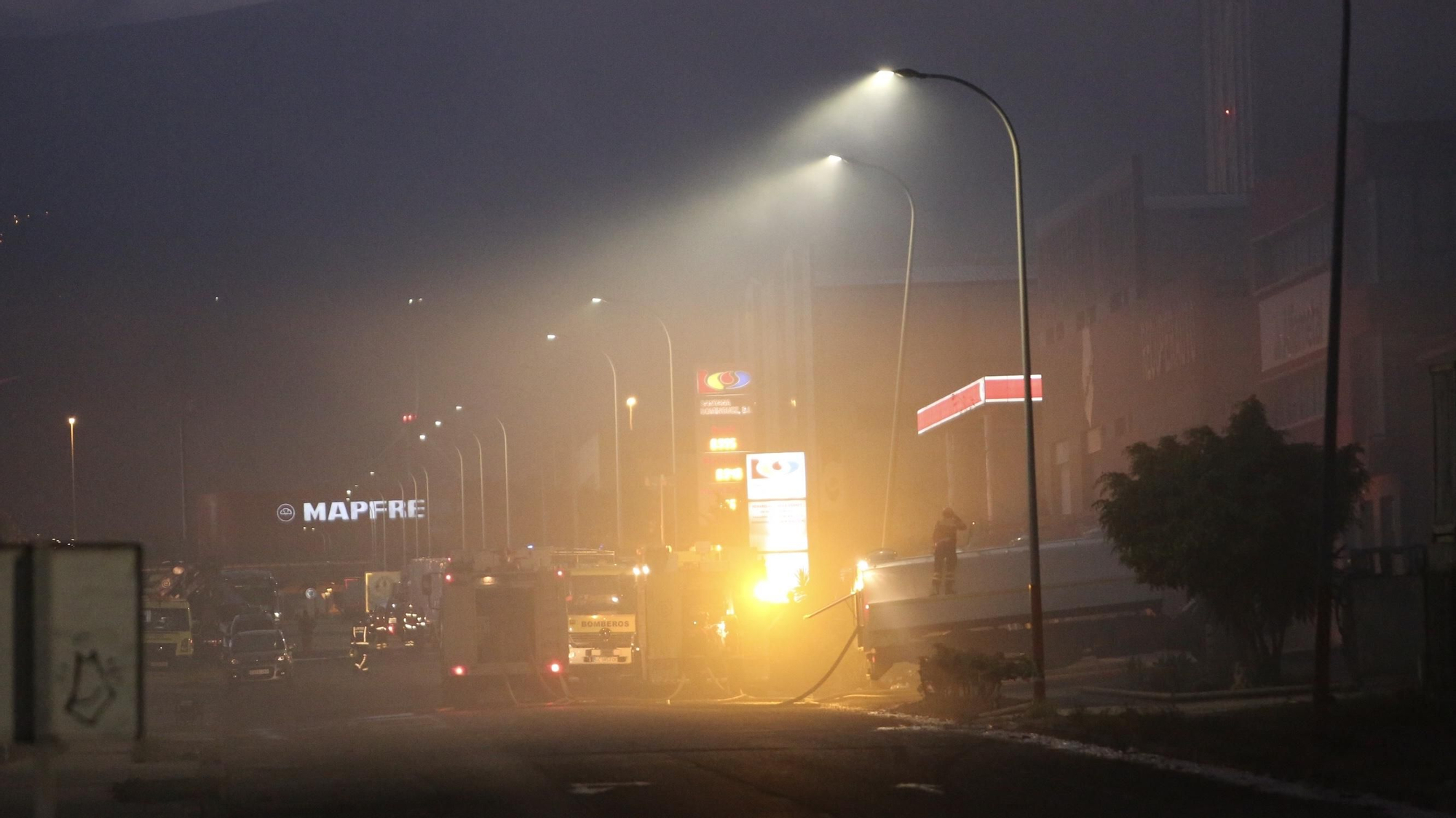 Los bomberos trabajan por controlar el incendio en una nave en Arinaga.
