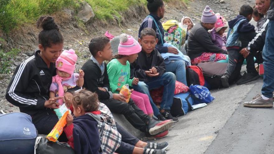 Familias venezolanas esperan este martes en una carretera del paso de Rumichaca, frontera entre Colombia y Ecuador.