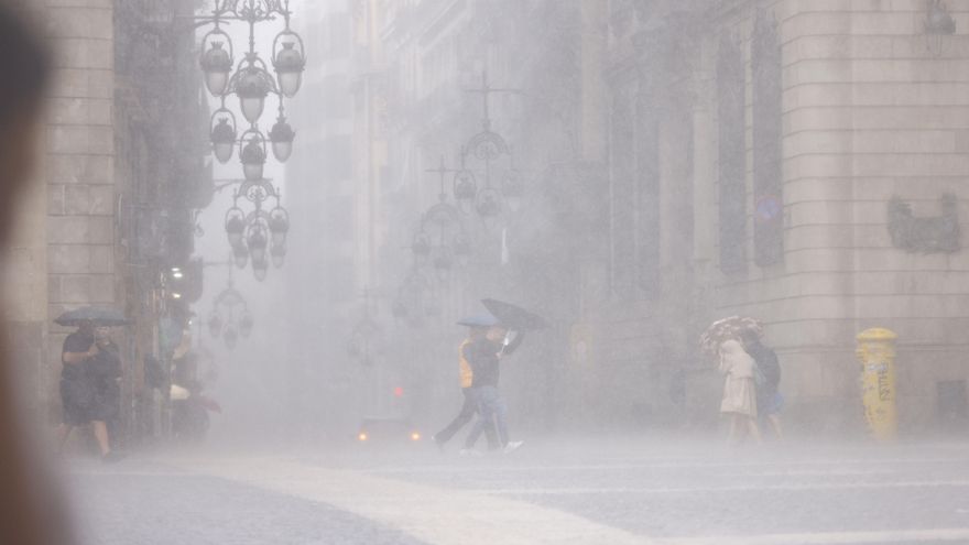 Personas se protegen de la lluvia en el centro de Barcelona. EFE/ Quique García
