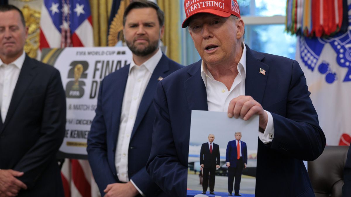 El presidente de EEUU, Donald Trump, sostiene una fotografía que, según él, le regaló el presidente ruso, Vladimir Putin, en el Despacho Oval de la Casa Blanca el 22 de agosto de 2025 en Washington, DC.