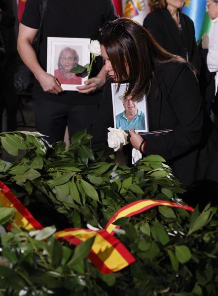Varios de los familiares de las 237 víctimas de la dana, depositan flores junto a la corona de laurel en recuerdo de los fallecidos