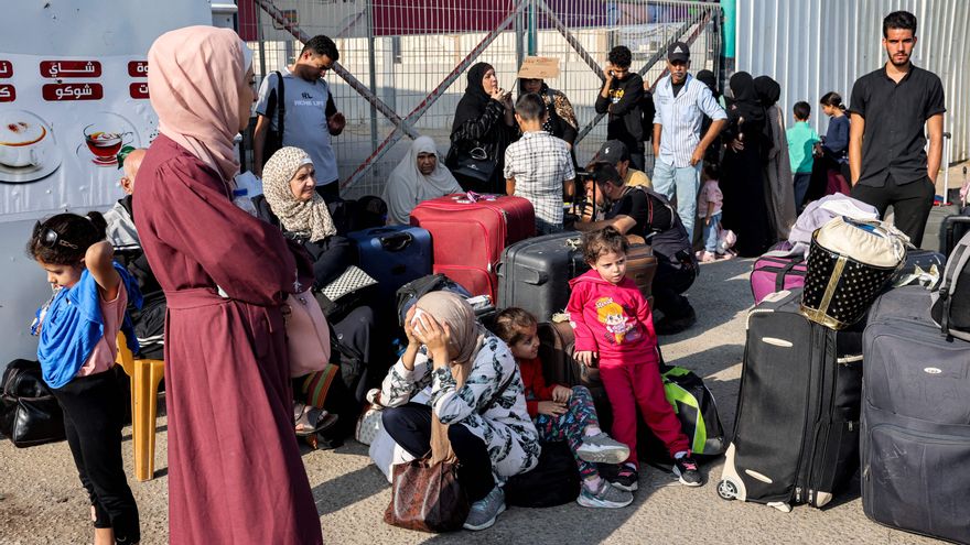 Varias personas esperan en el paso fronterizo de Rafah con Egipto, en el sur de la Franja de Gaza, el 1 de noviembre de 2023. Decenas de titulares de pasaportes extranjeros atrapados en Gaza comenzaron a abandonar el territorio palestino devastado por la guerra el 1 de noviembre.