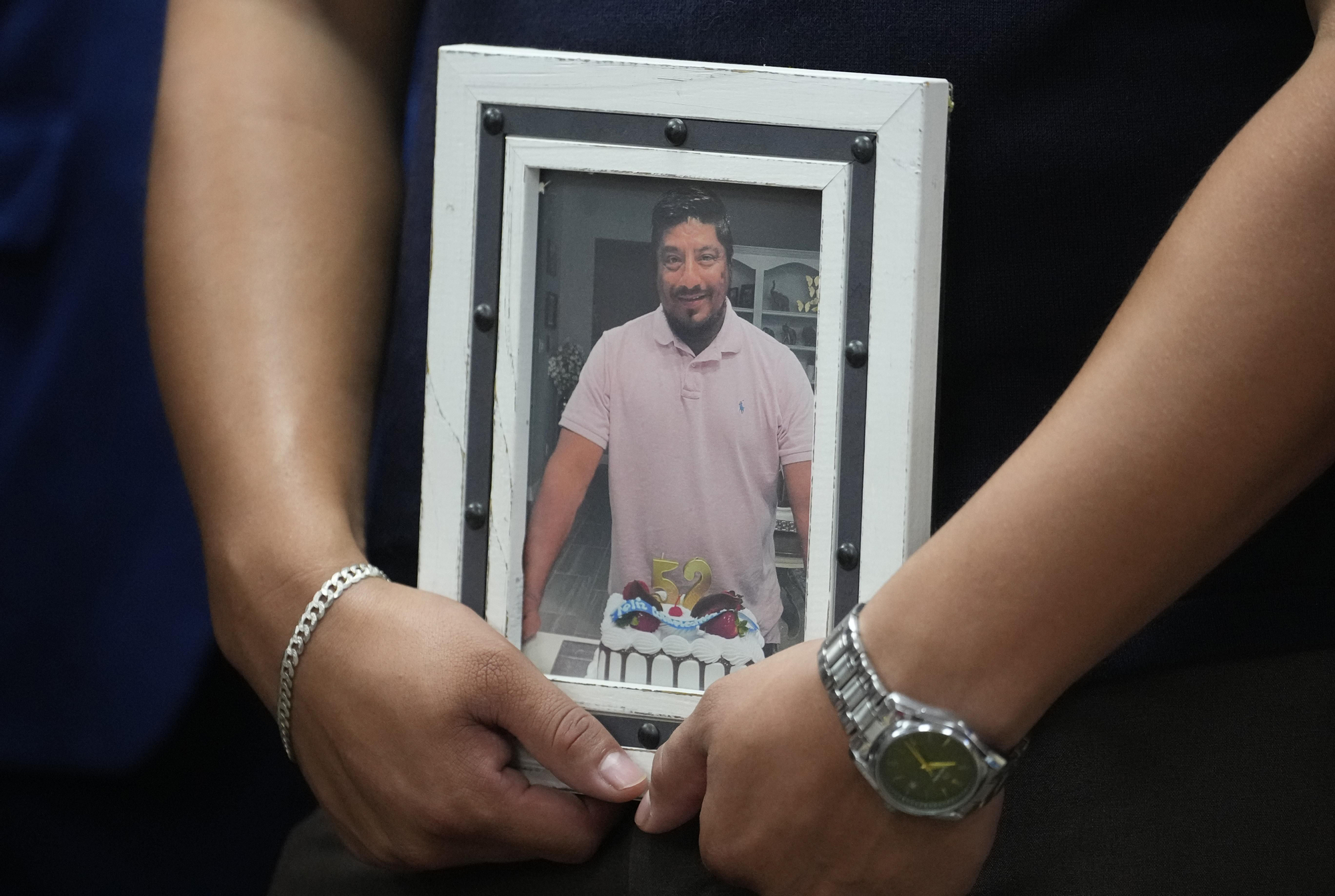 Ronaldo Salgado, hijo de Lorenzo Salgado Araujo, sostiene una foto de su padre durante una rueda de prensa sobre el homicidio por disparos de un agente del ICE en Houston, el miércoles 8 de julio de 2026.