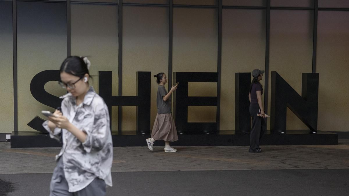 Varias personas pasan junto al logotipo de SHEIN frente a un edificio en Guangzhou, provincia de Guangdong, este viernes.
