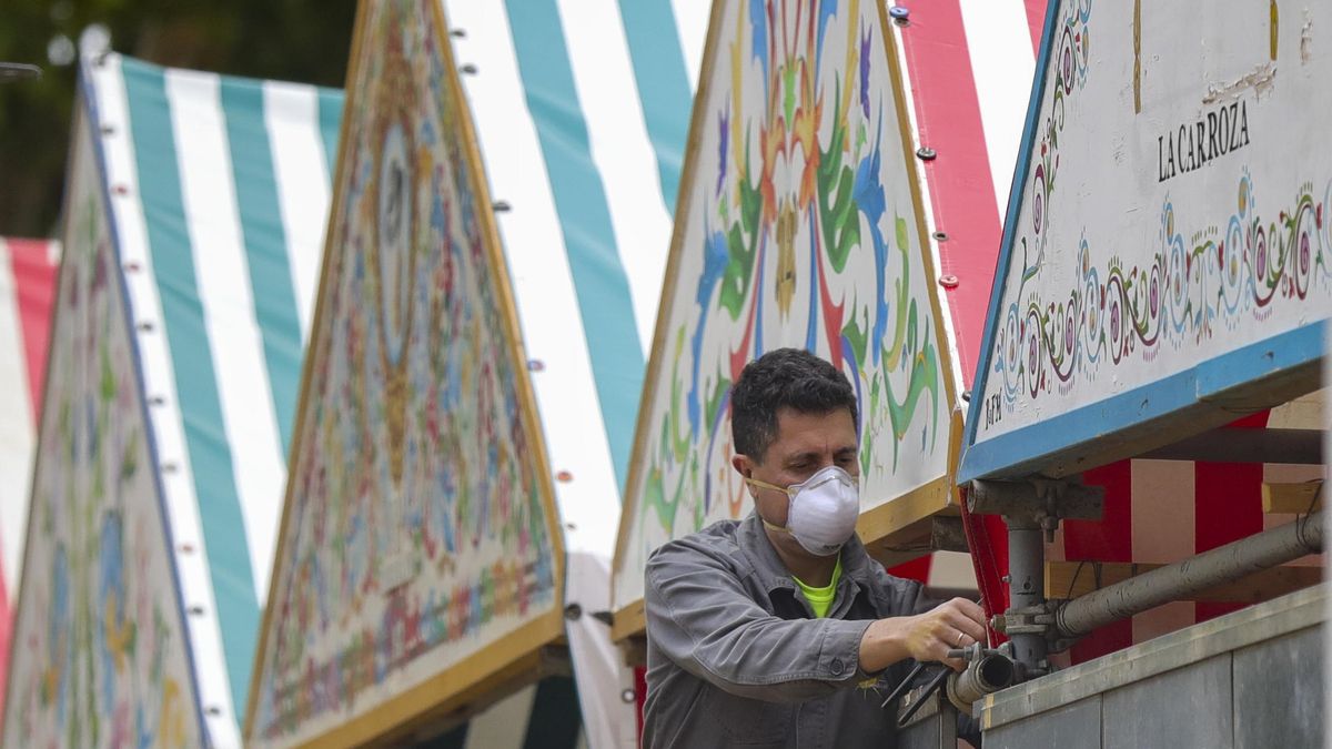 Archivo - Un operario trabajando en la instalación de las casetas de la Feria de Abril de Sevilla