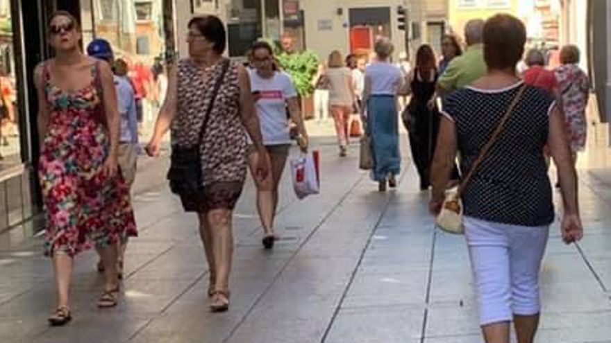 Personas paseando en una céntrica calle de Cáceres