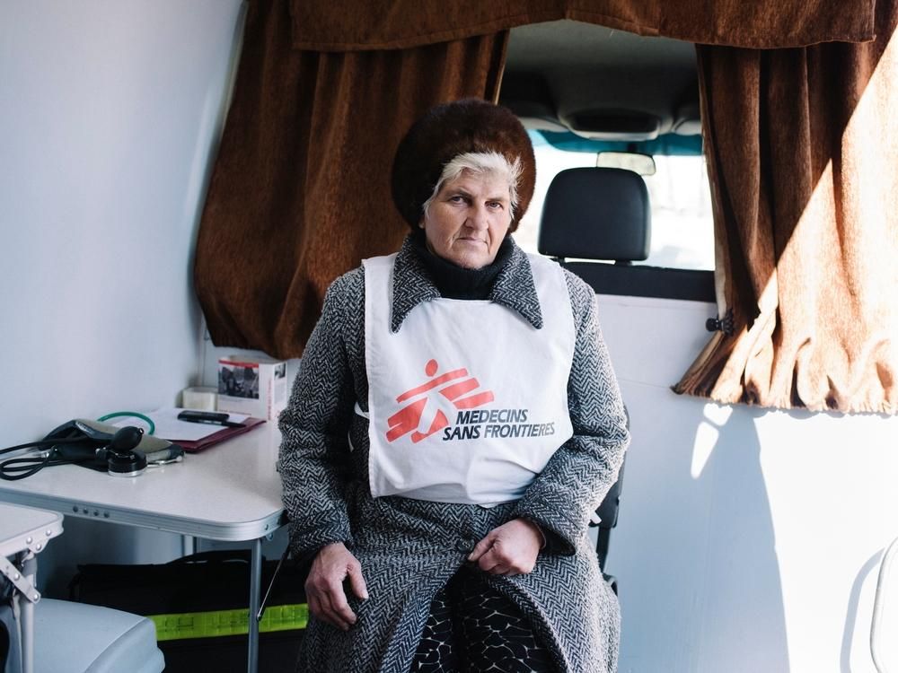 Una de las voluntarias de MSF posa en el interior de una clínica móvil, en Mayorsk, Ucrania. MSF ha establecido puntos de primeros auxilios y suministro de agua para ayudar a la población que debía esperar largas colas, en condiciones meteorológicas extremas (por frío o calor), para cruzar la línea del frente en los puestos de control de Artemovsk-Gorlovka, Volnavakha-Donetsk y Mayorsk. © Christopher Nunn/MSF