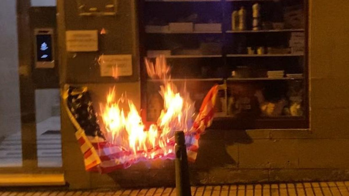 Un grupo de activistas quema una bandera de Estados Unidos ante el consulado en Las Palmas