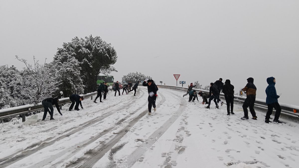 Varias personas se lanzan bolas de nieve en la carretera M-519 a la altura de Galapagar, este miércoles, en el que la borrasca Kristin deja una nevada en la región de Madrid