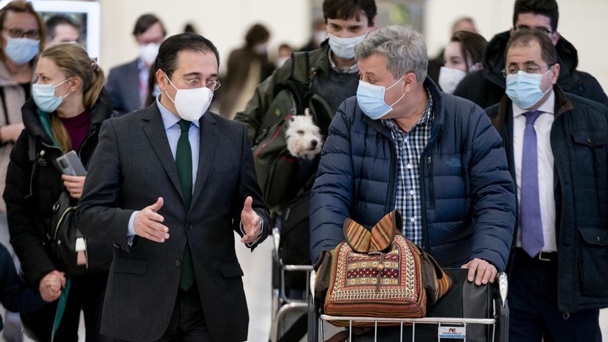 El ministro de Asuntos Exteriores, Unión Europea y Cooperación, José Manuel Albares (i), conversa con varios españoles repatriados a su llegada al Aeropuerto Adolfo Suárez Madrid Barajas, a 28 de febrero de 2022, en Madrid (España).