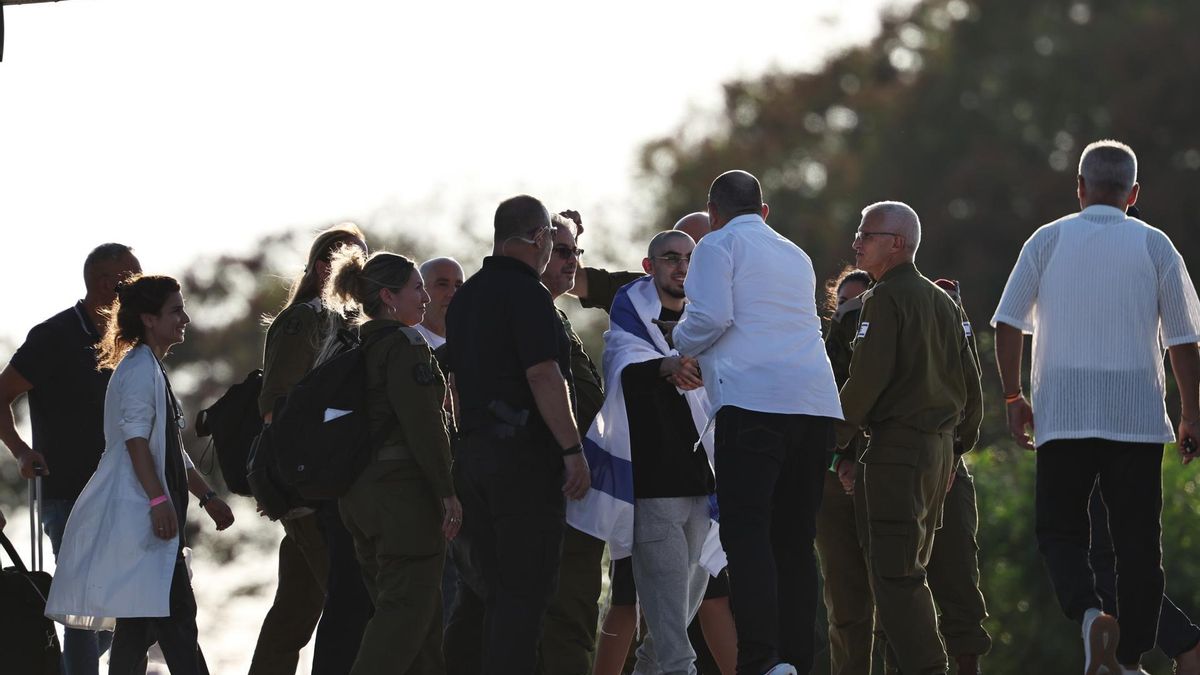 Rom Braslavski, con una bandera israelí sobre los hombros, saluda a uno de los médicos del Hospital Sheba en Ramat Gan a su llegada.