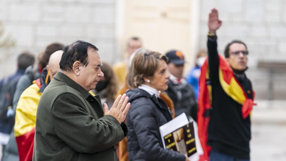 Un hombre reza mientras otro realiza el saludo fascista ante el panteón de la familia Franco, en el cementerio de Mingorrubio (Madrid).