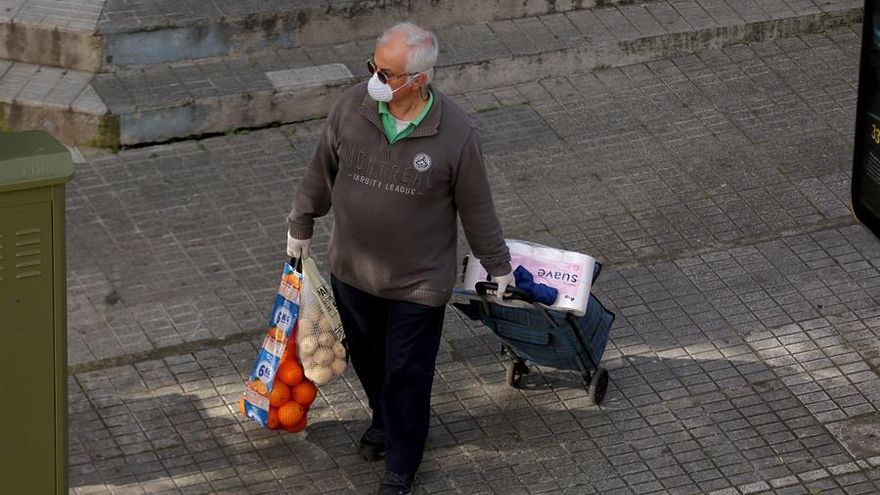 Un señor regresa a casa después de realizar la compra este viernes, tras más de veinte días de la declaración del estado de alarma para frenar la expansión del coronavirus
