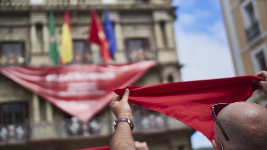 Archivo - Un hombre alza un pañuelo rojo en las inmediaciones de la Plaza del Consistorio en el momento en el que de celebrarse los Sanfermines 2020.