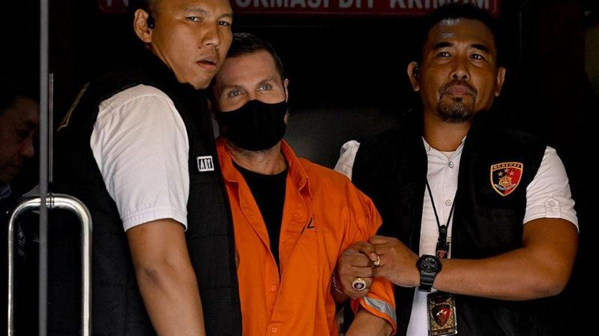 Steven Lyons es escoltado por agentes de policía en la sede de la policía de Bali, en Denpasar, en la isla turística indonesia de Bali, el 31 de marzo de 2026. Indonesia deportará a Lyons, buscado por la Interpol por presunto tráfico transnacional de drogas y lavado de dinero. (Foto de SONNY TUMBELAKA / AFP vía Getty Images)