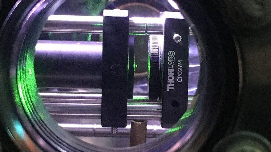 El diminuto punto verde en el centro de la imagen es un nanodiamante (aproximadamente 0,00000004 m) que levita en vacío gracias a la acción de un láser infrarrojo focalizado (pinzas ópticas). Experimento llevado a cabo por A. C. Frangeskou, A. T. M. A. Rahman, L. Gines, S. Mandal, O. A. Williams, P. F. Barker y G. W. Morley.