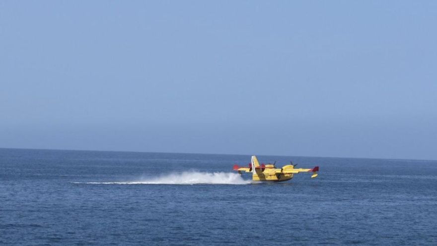 Un hidroavión realiza una maniobra para cargar de agua los depósitos en la playa de Las Canteras este lunes