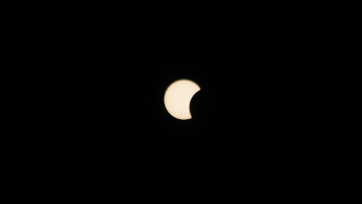 Vista parcial del Sol siendo cubierto por la Luna durante el eclipse del 12 de agosto