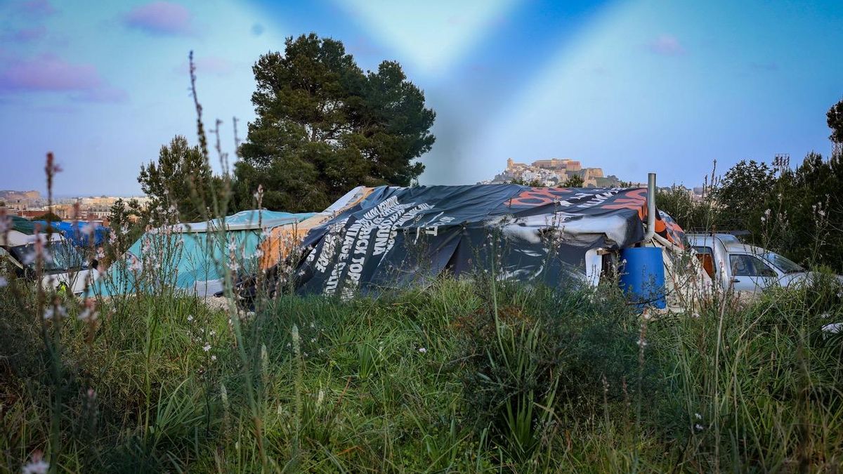 Una lona de discoteca cubre una de las chabolas de Can Misses; al fondo, Dalt Vila, un barrio histórico catalogado como Patrimonio Mundial por la Unesco.
