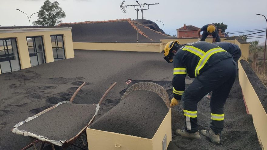 Bomberos trabajan en la retirada de cenizas en viviendas en La Palma.