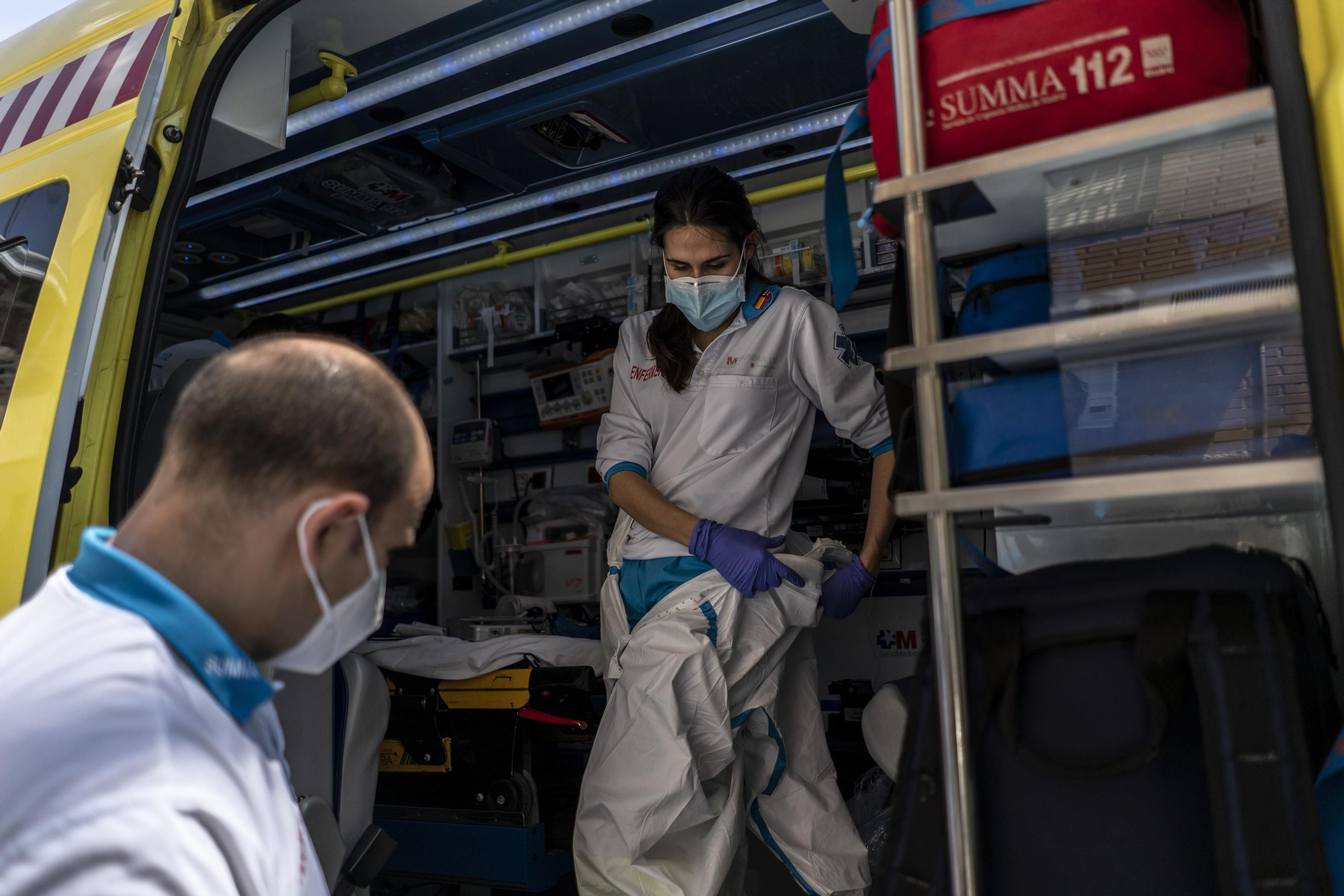 Ana Moreno, enfermera,  se viste con un equipo de protección individual (EPI) ayudada por Ignacio Crespo, técnico en emergencias.