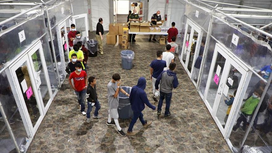 Fotografía del 17 de marzo cedida por la Oficina de Aduanas y Protección de Fronteras (CBP) donde se muestra a un grupo de niños haciendo cola para tomar alimentos en las instalaciones de procesamiento temporal en Donna, Texas. El Gobierno de Estados Unidos divulgó este martes dos videos que muestran las condiciones de vida en dos instalaciones de Texas donde cientos de niños migrantes permanecen bajo custodia de la Oficina de Aduanas y Protección de Fronteras (CBP