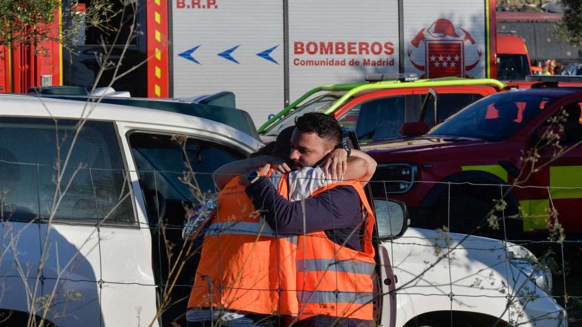 Dos personas se abrazan tras el accidente en Urda, Toledo, este miércoles.