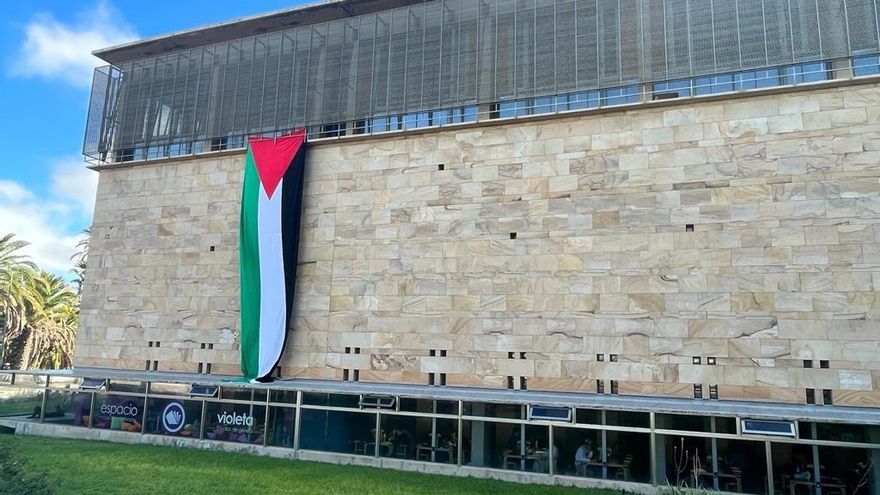 Empleados de la Biblioteca de la Universidad de Las Palmas de Gran Canaria despliegan una bandera palestina en su fachada