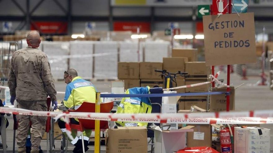 Sanitarios y personal militar trabajan en el almacén del hospital temporal, montado en el pabellón 10 del centro de exposiciones Ifema, reconvertido en hospital temporal, durante la puesta en marcha de las primeras UCIs para atender pacientes de coronavirus, este miércoles, en Madrid.