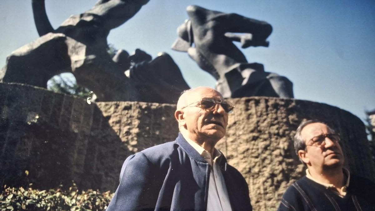 Benjamín Rubio, con su hijo Javier, junto al monumento al minero de Villablino.