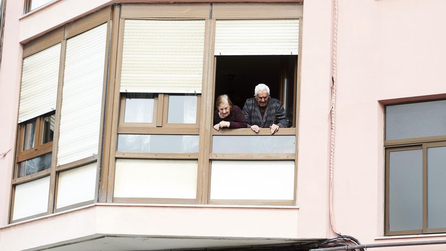 Unos ancianos asomados a la ventana.