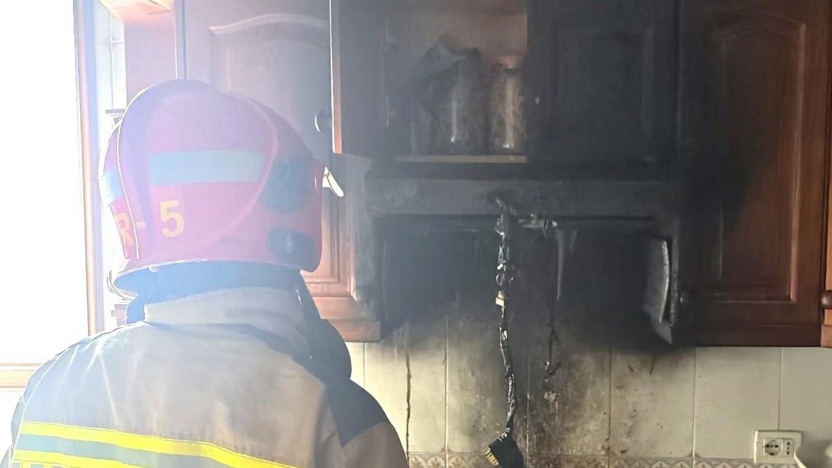 Un bombero en la cocina afectada por el incendio del extractor.
