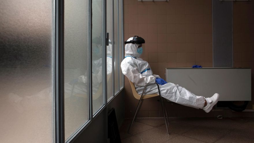 Una profesional sanitaria descansa tras varias horas realizando pruebas PCR. EFE/Enric Fontcuberta/Archivo