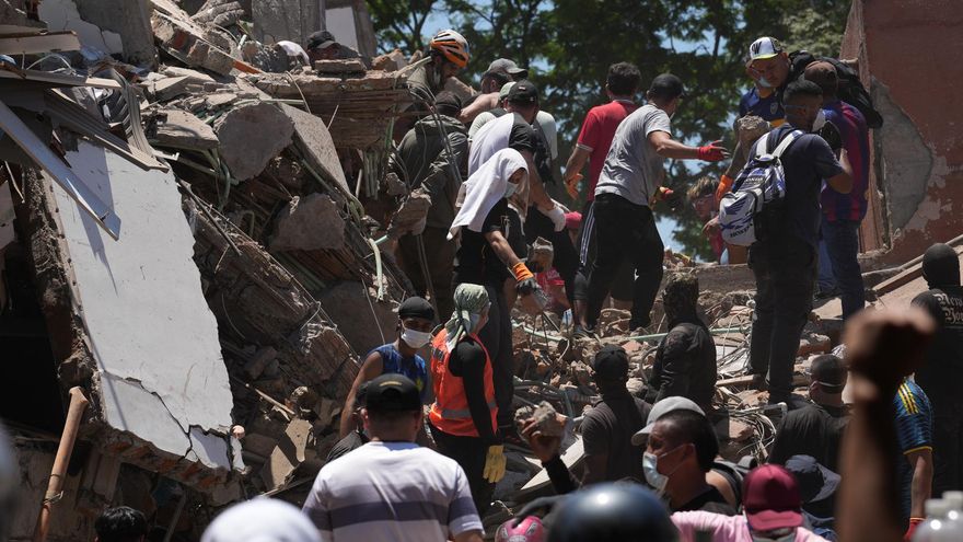 Integrantes del cuerpo de Bomberos de Cali y civiles buscan entre los escombros en la ciudad de Cali (Colombia).