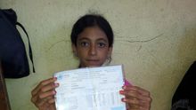 Ola muestra la cartilla de racionamiento de la familia con la que cada 3 meses recogen alimentos de la UNRWA. Foto: Isabel Pérez, mayo 2014