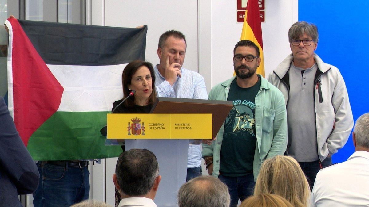 Un miembro del comité de empresa despliega la bandera palestina en un acto con Margarita Robles en Navantia Ferrol