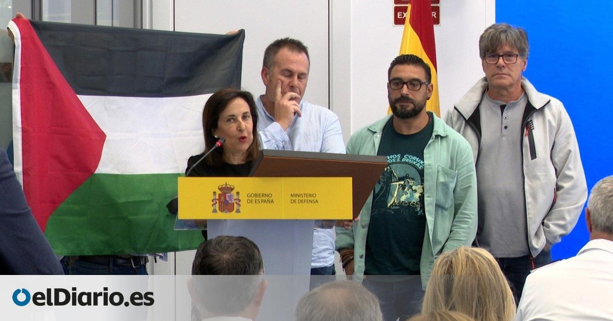 Un miembro del comité de empresa despliega la bandera palestina en un acto con Margarita Robles en Navantia Ferrol